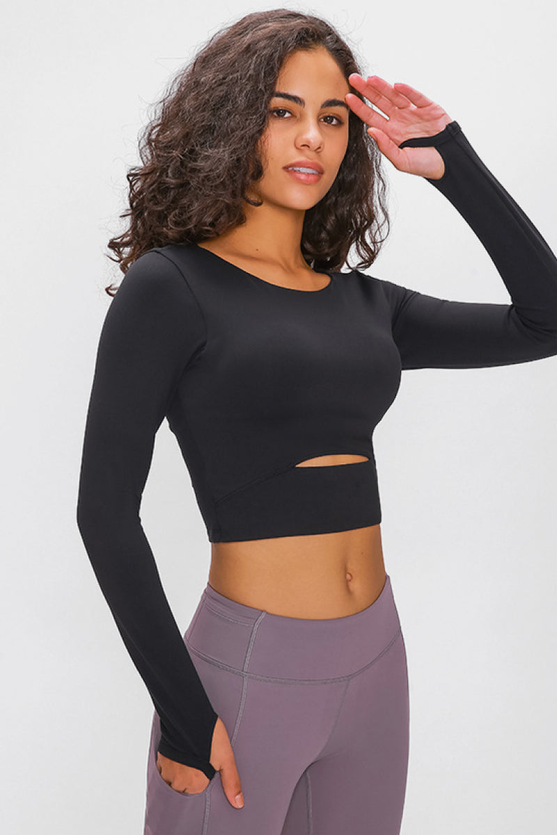 Woman wearing a long-sleeved, cropped workout top in black, fitted with a support strap, for high-impact activewear.